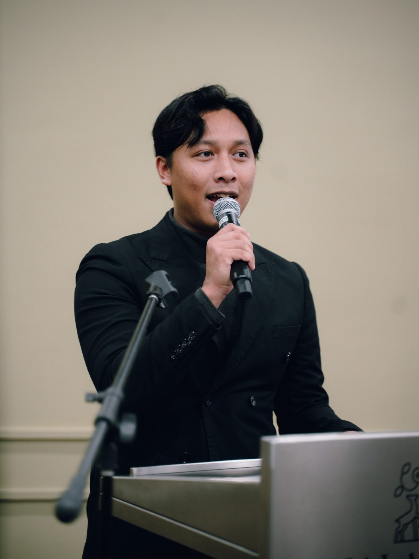 Irfan delivering a formal address on stage